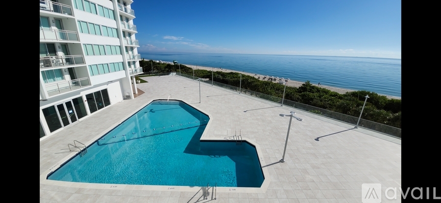 A swimming pool on a balcony overlooking the ocean.