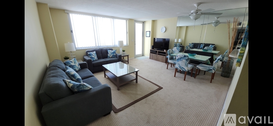 A living room with a grey couch and a glass coffee table.