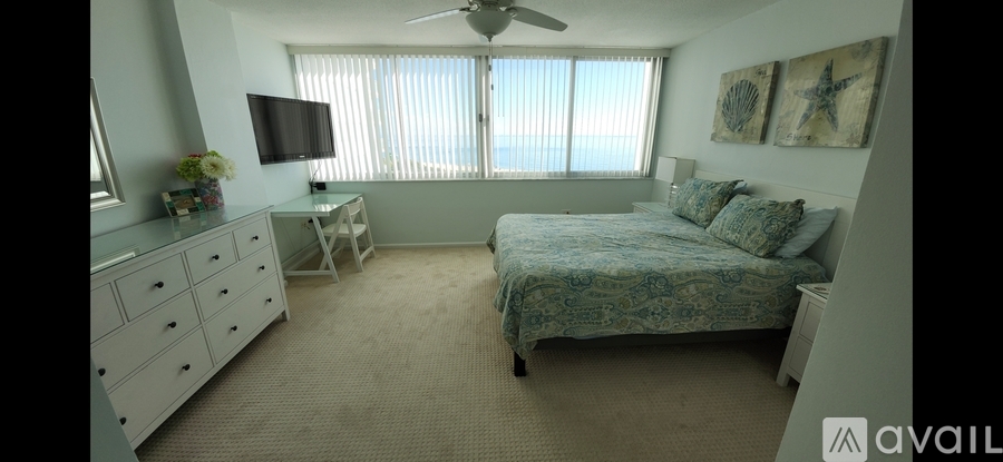 A bedroom with a bed, dresser, and ceiling fan.