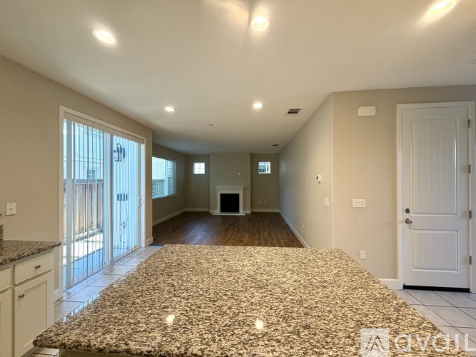 A spacious living room with a fireplace and a large rug.