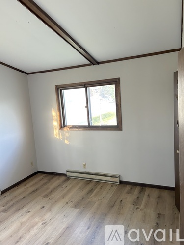 A room with wooden floors and a window.