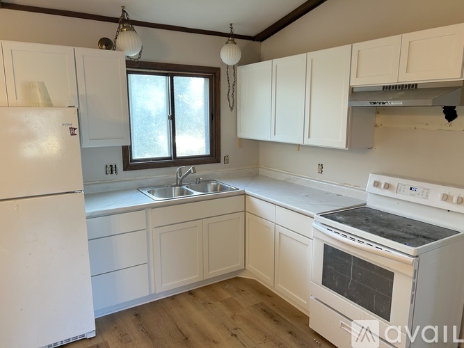 A kitchen with white appliances and cabinets.