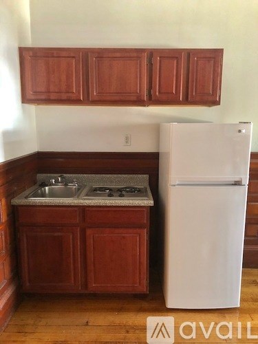 A kitchen with wooden cabinets and a white fridge.
