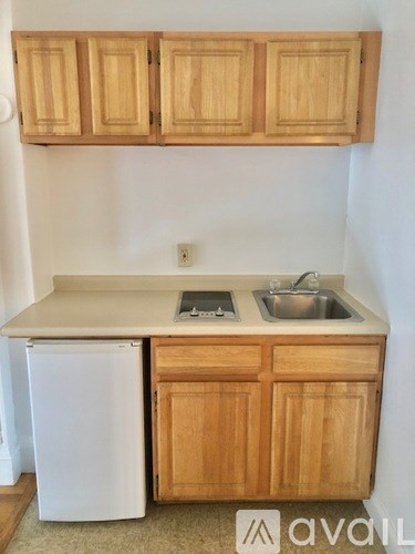 A kitchen with wooden cabinets and a white fridge.