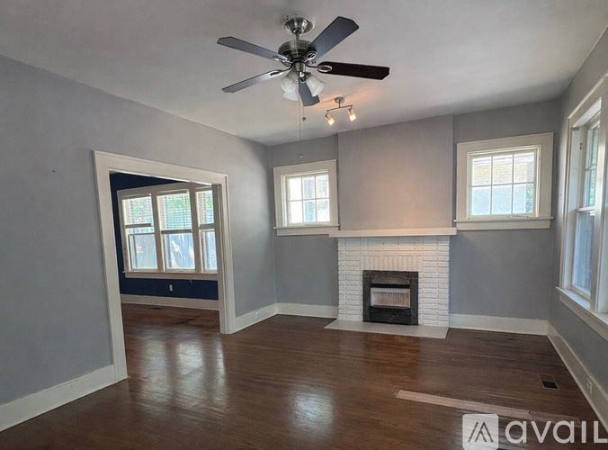 A room with a fireplace and a ceiling fan.