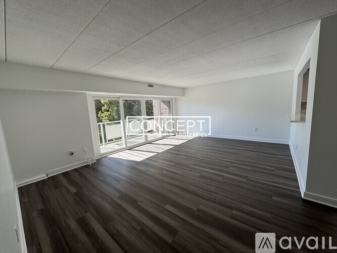 A room with wooden flooring and a sliding glass door leading outside.