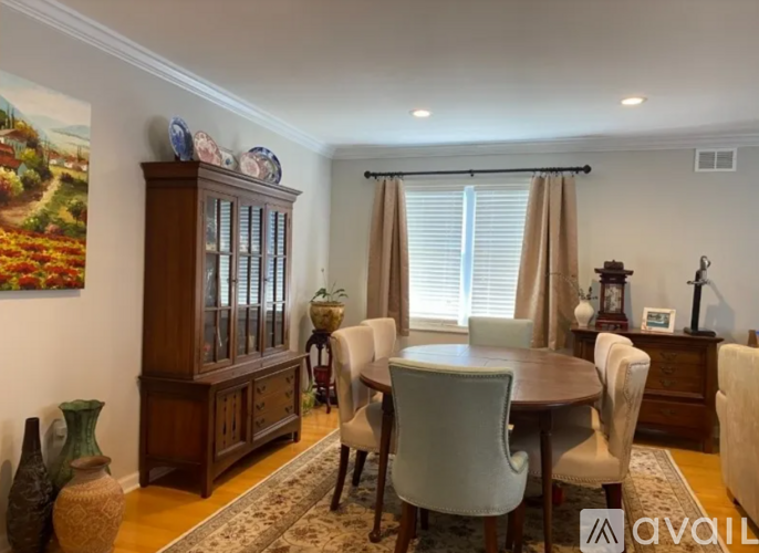 A dining room with a wooden table and chairs.