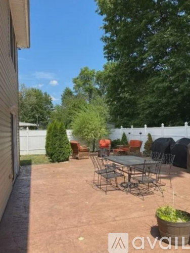 A patio with a table and chairs surrounded by trees.