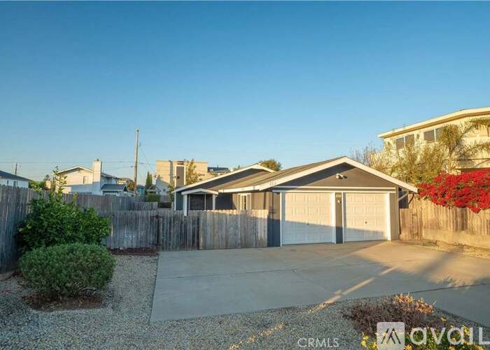 A house with a garage and a driveway in front of it.