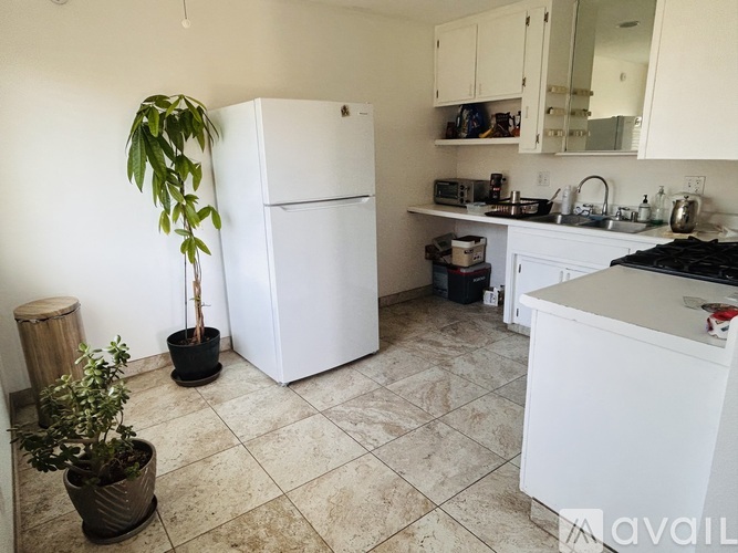 A kitchen with a white refrigerator and a white countertop.