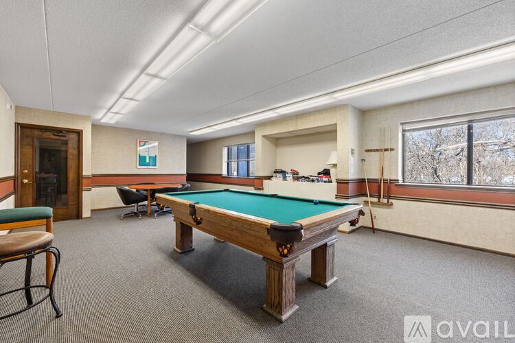 A room with a pool table and a chair.