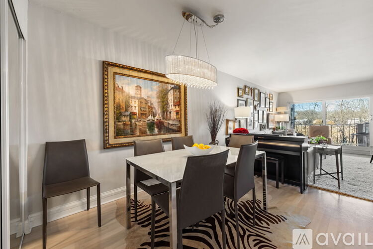 A dining room with a white table and chairs, a zebra rug, and a painting on the wall.