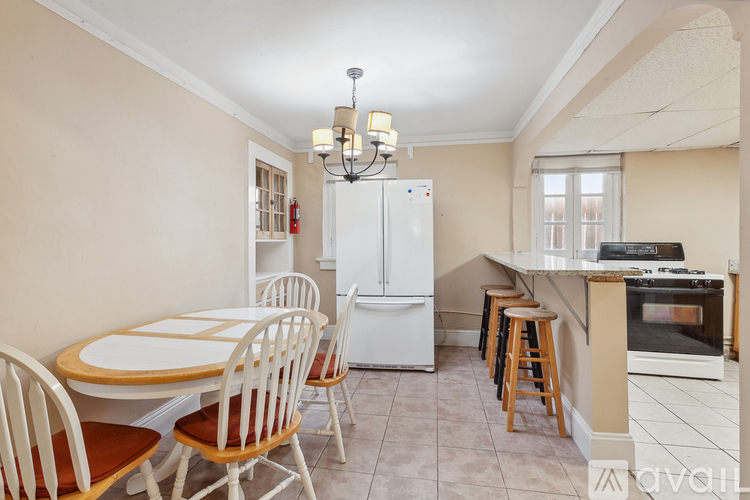 A kitchen with a table and chairs.