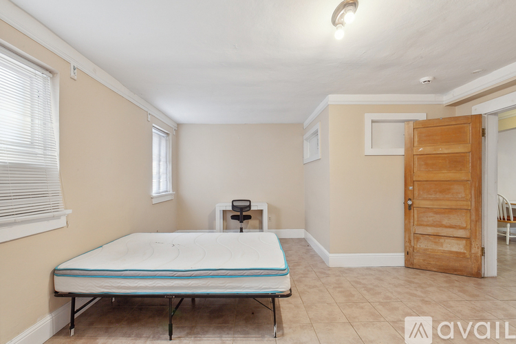A bedroom with a bed, chair, and exercise equipment.