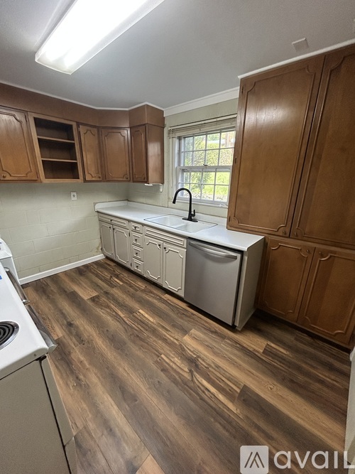 A kitchen with wooden cabinets and a white dishwasher.