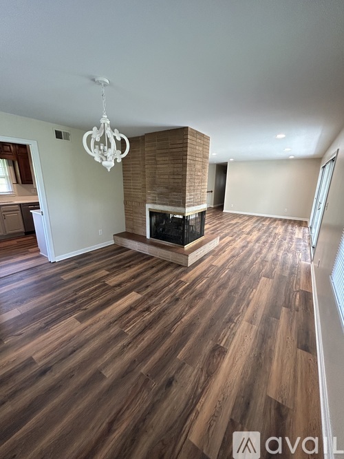 A living room with a fireplace and wood flooring.