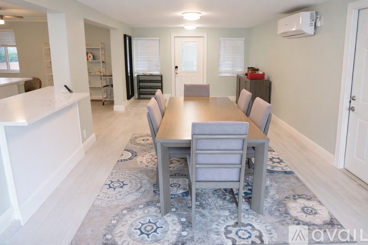 A dining room with a table and chairs.