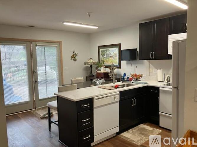 A kitchen with black cabinets and white appliances.