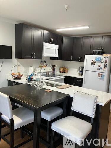 A kitchen with a table and chairs.