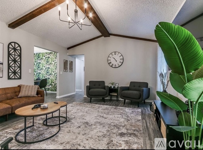 A living room with a sofa, armchairs, and a coffee table.
