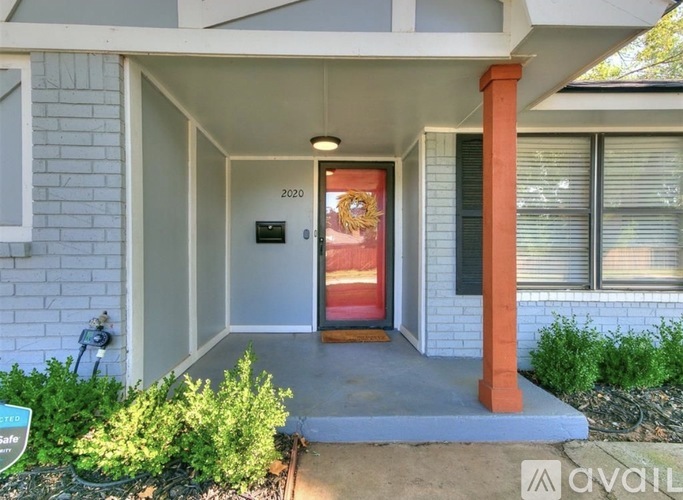 A house entrance with a red door and a sign that says 2020.