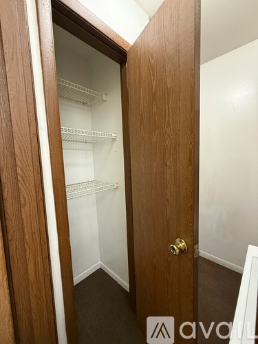 A wooden door with a glass window is open to reveal a white interior.