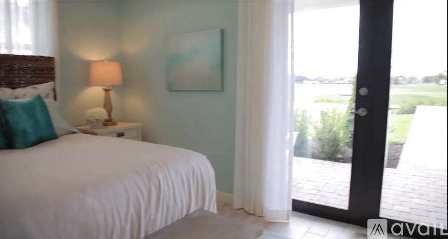 A bedroom with a white bed and a painting on the wall.