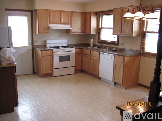 A kitchen with wooden cabinets and a white stove top oven.