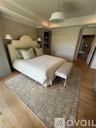 A bedroom with a large bed and a bench at the foot of the bed.