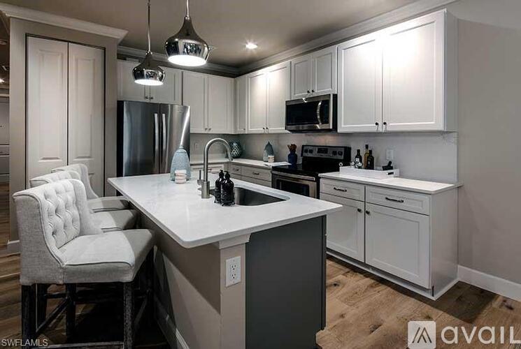 A kitchen with white cabinets and a large island.