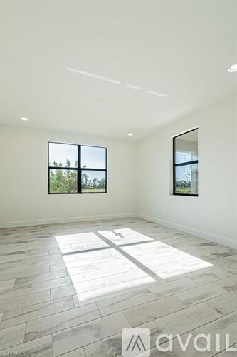 A spacious room with a large window and a mirror on the wall.