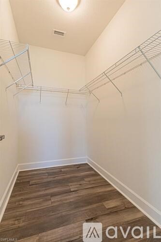 A hallway with a wood floor and a wall-mounted shelf.