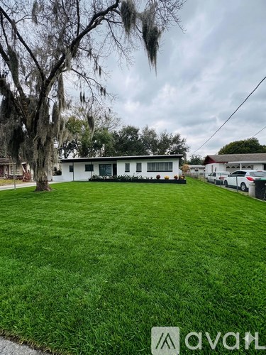 A white house with a green lawn in front of it.