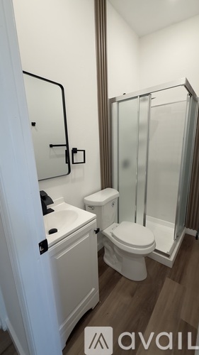 A white toilet and sink in a small bathroom.