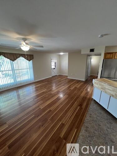 A room with wooden flooring and a ceiling fan.