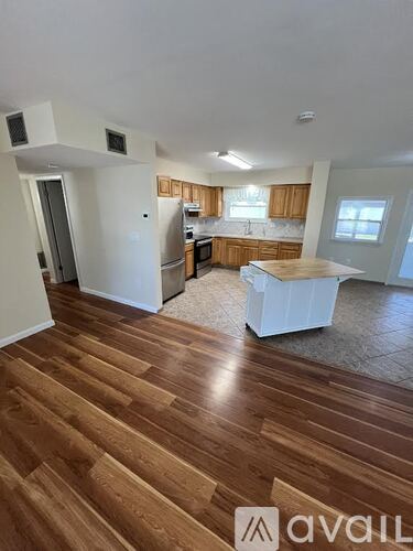 A wooden floor spans the length of the kitchen and living room.