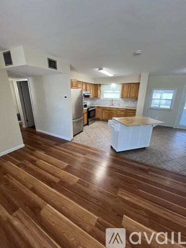 A wooden floor spans the length of the kitchen and living room.