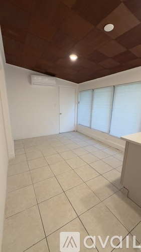 A room with a brown ceiling and white walls.