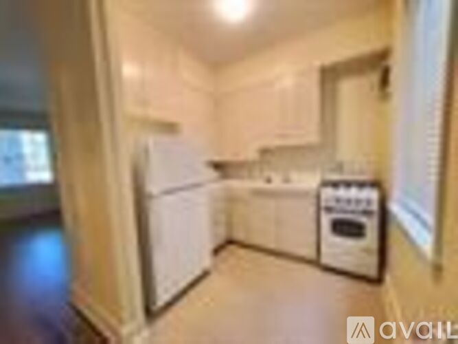 A kitchen with white appliances and wooden floors.