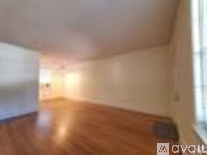 A room with wooden flooring and white walls.