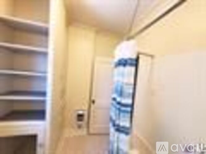 A small, white, and beige kitchen with a refrigerator and a microwave.