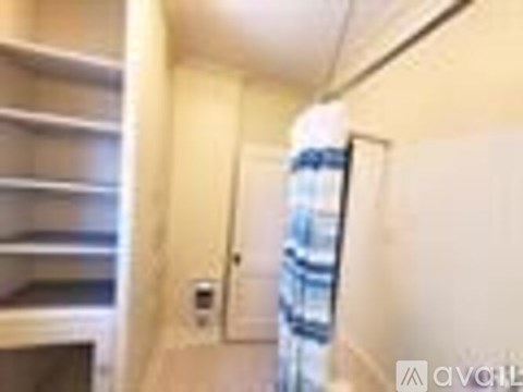A small, white, and beige kitchen with a refrigerator and a microwave.