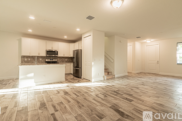 A spacious kitchen with a refrigerator, microwave, and oven.