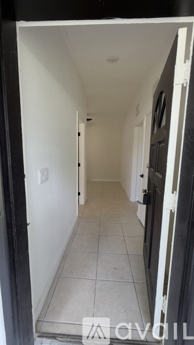 A hallway with a white door and a black door.