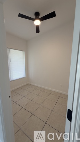 A room with a ceiling fan and tiled floor.