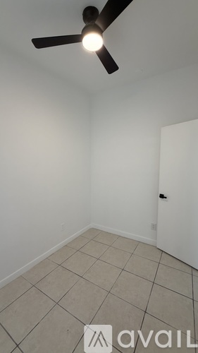 A room with a ceiling fan and tile flooring.