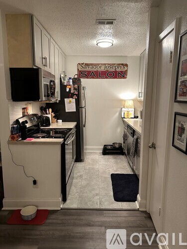 A kitchen with a refrigerator and a microwave.
