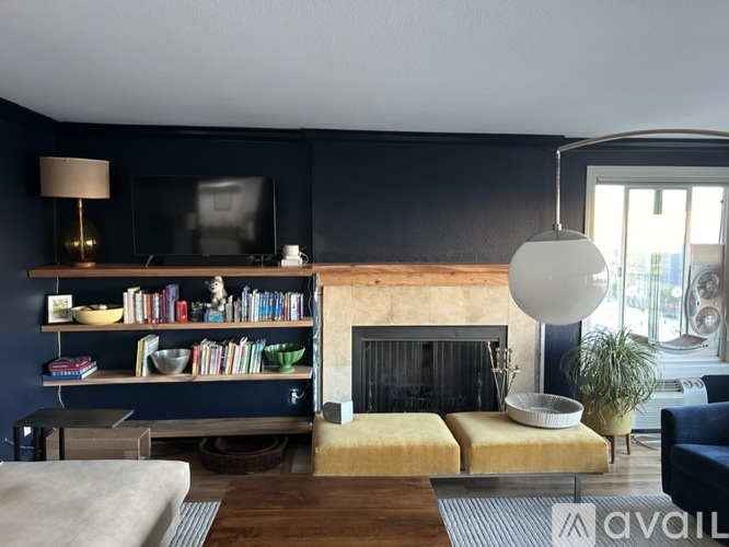 A living room with a fireplace and a television on the wall.
