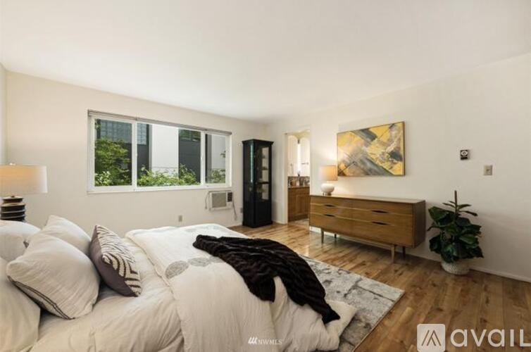 A bedroom with a large bed and a wooden dresser.