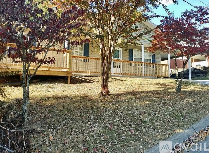 A house with a porch and trees in front.